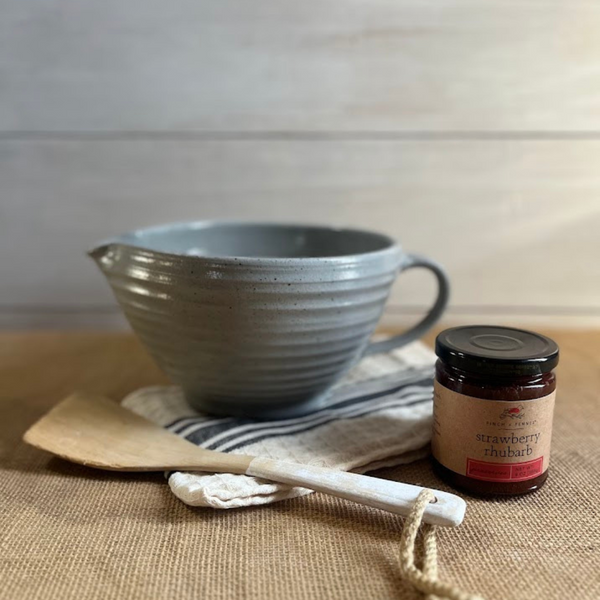 Ridges handled batter bowl in agrarian gray pictured with a mixing spoon and handmade jelly