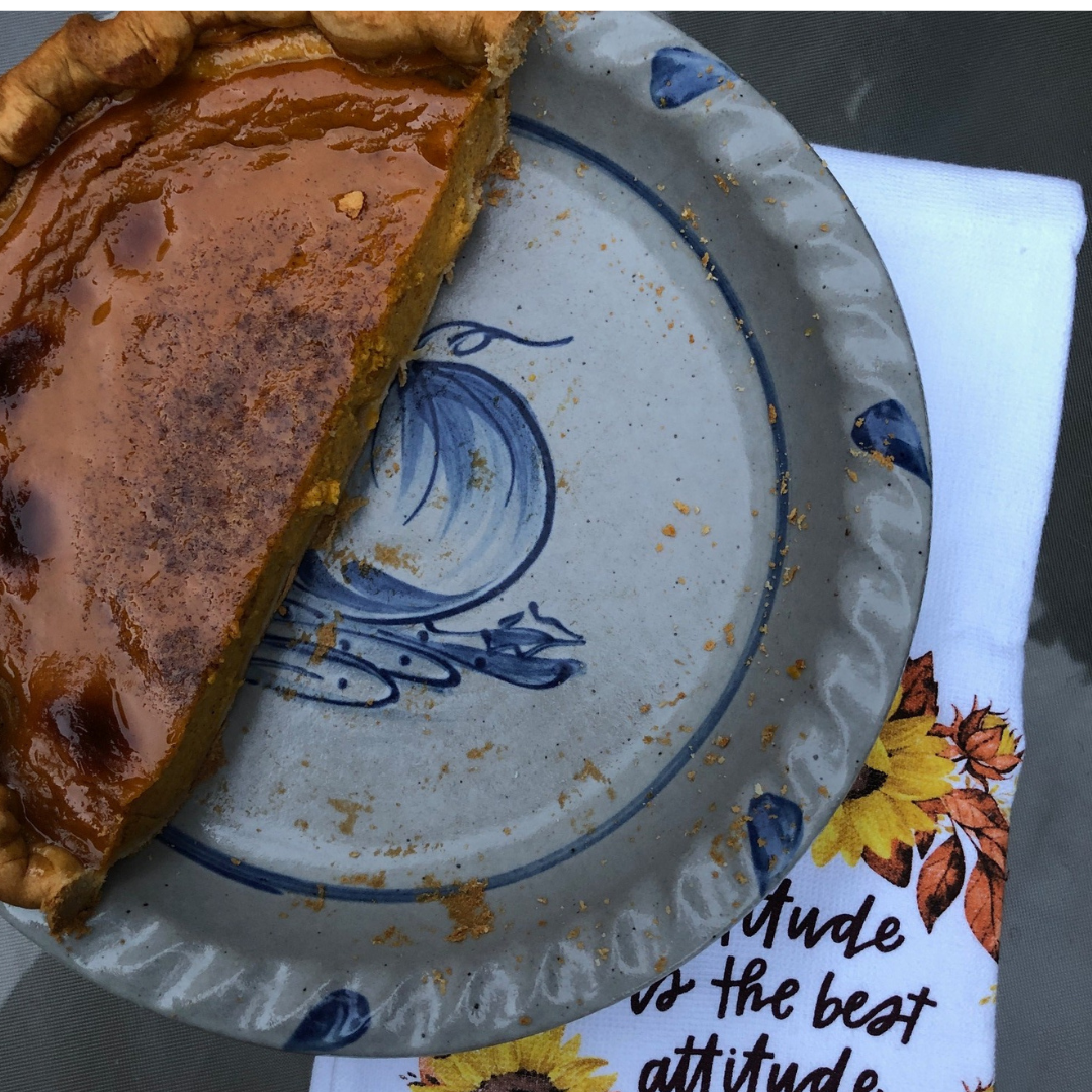 Rowe Pottery handmade stoneware pie plate with Pumpkin pattern with half of a pumpkin pie