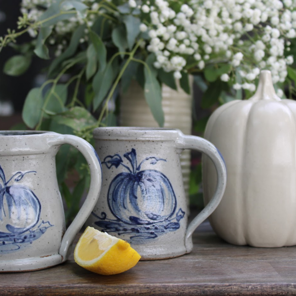 Rowe Pottery Hand thrown stoneware mug In a hand decorated pumpkin pattern with decorative background
