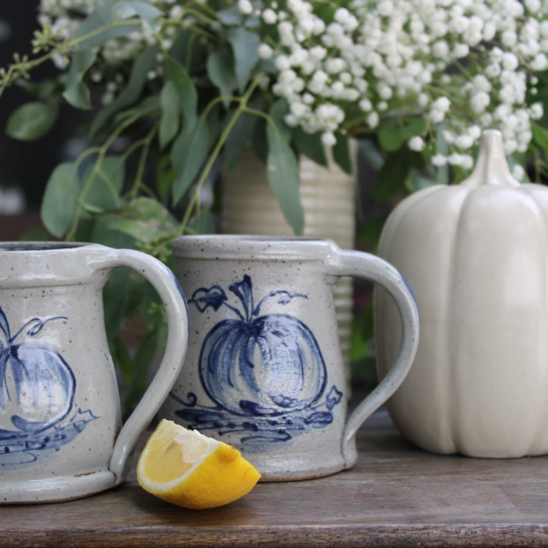 Rowe Pottery Hand thrown stoneware mug In a hand decorated pumpkin pattern with decorative background