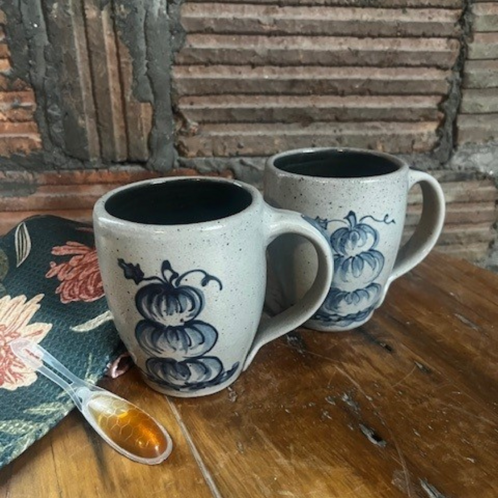 Two Rowe Pottery hand thrown mugs with the stacked pumpkin pattern side by side