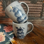 Two Rowe Pottery hand thrown mugs with the stacked pumpkin pattern stacked